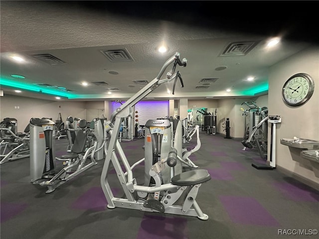 gym featuring a textured ceiling and visible vents