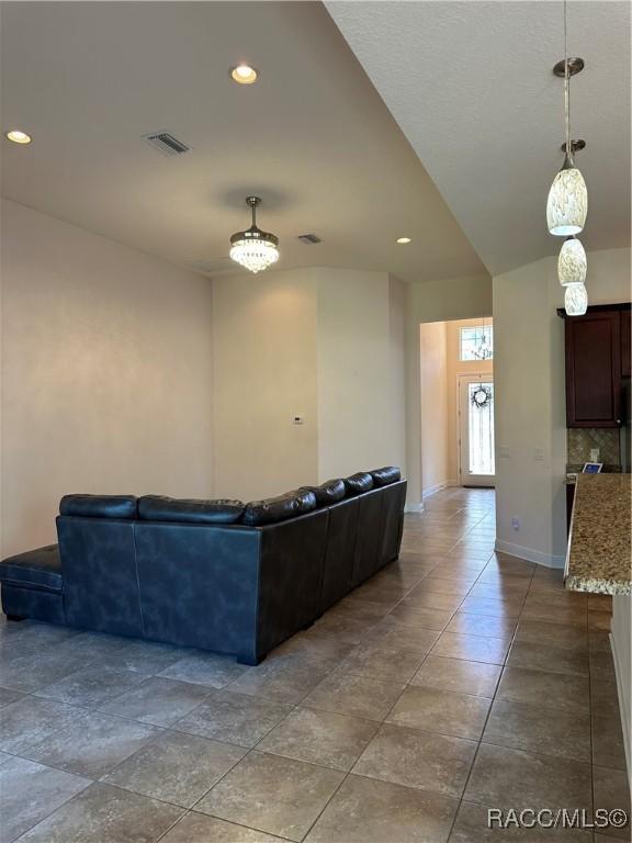 living area with recessed lighting, visible vents, and baseboards