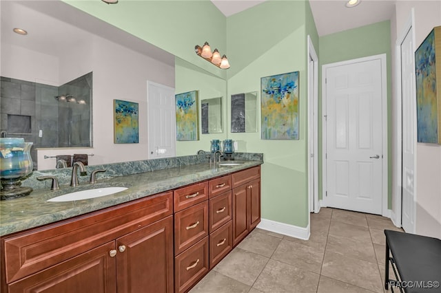 bathroom featuring tile patterned flooring, vanity, and a tile shower