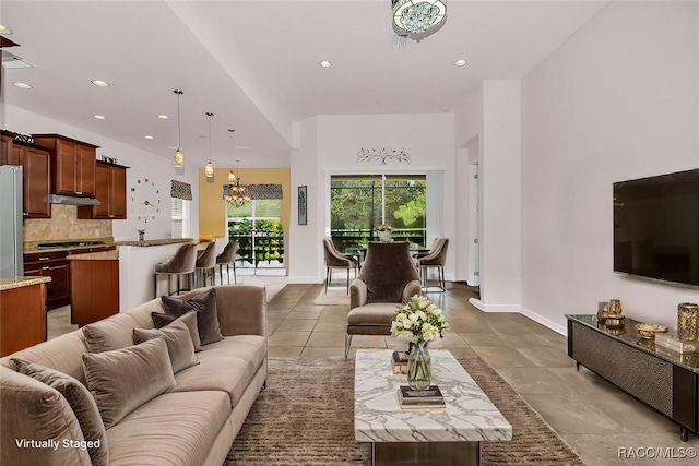 tiled living room with a notable chandelier