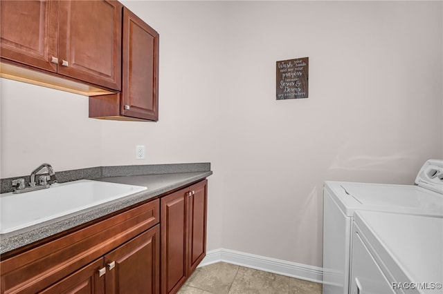 laundry room with independent washer and dryer, cabinet space, a sink, and baseboards