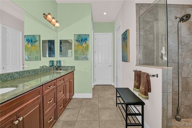 full bath with double vanity, walk in shower, tile patterned flooring, and a sink