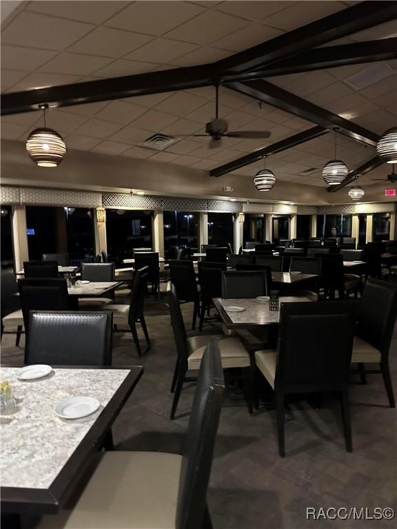 dining area with a paneled ceiling, visible vents, and beamed ceiling