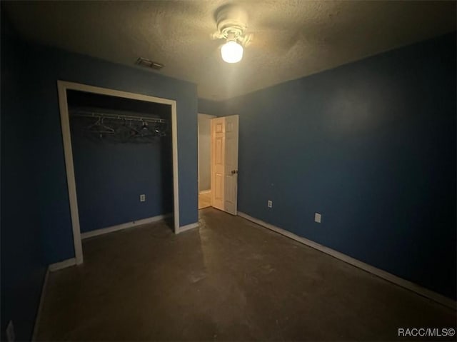 unfurnished bedroom with ceiling fan, a closet, and a textured ceiling