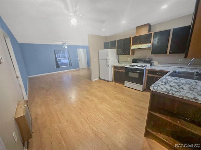 kitchen featuring light stone counters, white appliances, ceiling fan, sink, and light hardwood / wood-style floors