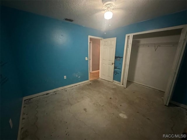 unfurnished bedroom featuring a textured ceiling, a closet, and ceiling fan