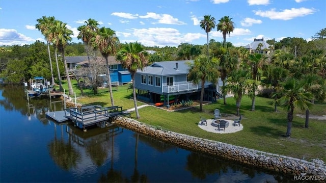 12046 W Gulf Breeze Ct, Crystal River, FL 34429 - dock area with an outdoor fire pit, a water view, a yard, and boat lift