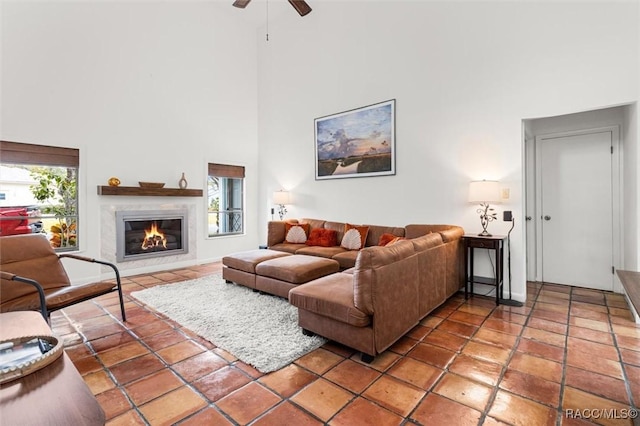 living room with ceiling fan, tile patterned floors, and a high ceiling