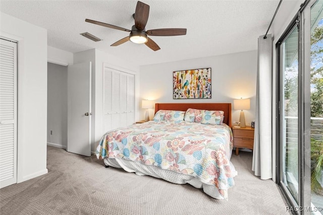 carpeted bedroom featuring access to outside, ceiling fan, a closet, and a textured ceiling