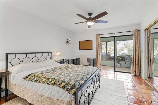 bedroom featuring ceiling fan, light tile patterned floors, access to exterior, and a textured ceiling