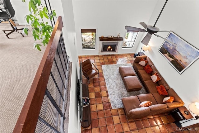 tiled living room with ceiling fan and a towering ceiling