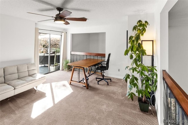 carpeted office space with a textured ceiling and ceiling fan