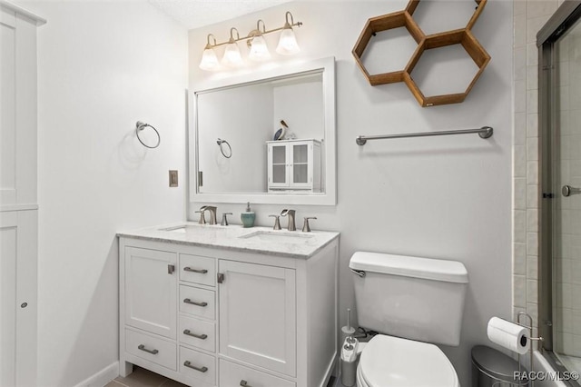 bathroom with toilet, vanity, and an enclosed shower