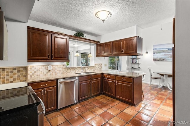 kitchen featuring kitchen peninsula, appliances with stainless steel finishes, stone counters, pendant lighting, and sink