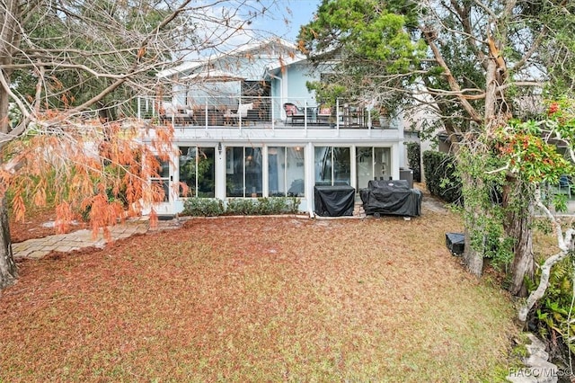 back of house featuring a sunroom and a balcony