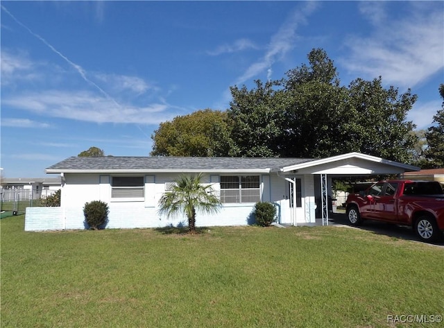 ranch-style house featuring a front lawn, a carport, and fence