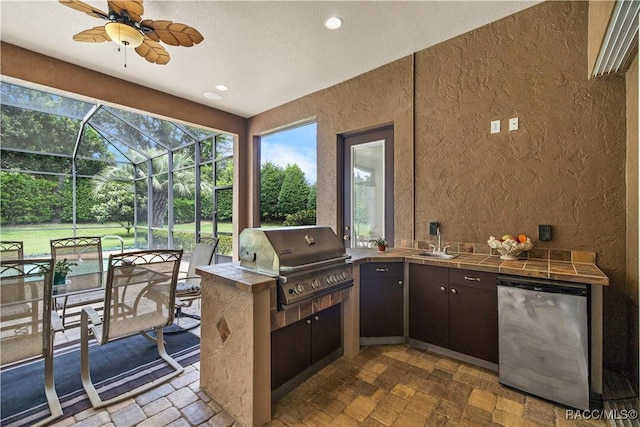 view of patio / terrace with ceiling fan, area for grilling, sink, glass enclosure, and grilling area