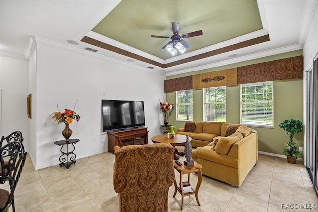 living room with ceiling fan, light tile patterned floors, crown molding, and a tray ceiling