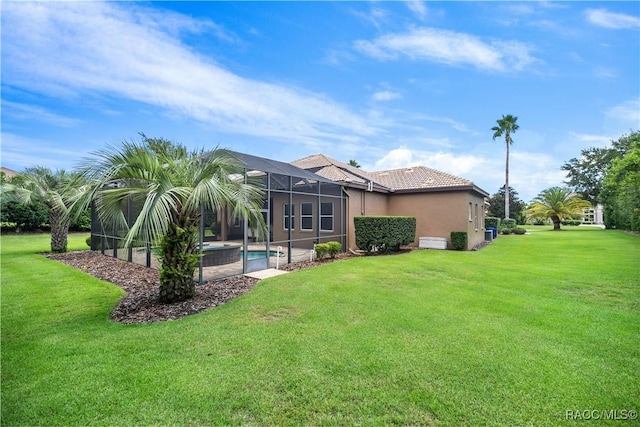 back of house with a lanai and a yard