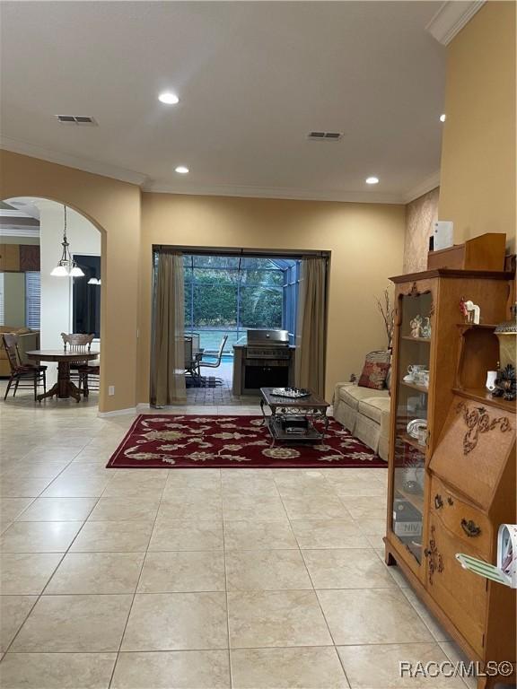 interior space with light tile patterned floors and crown molding