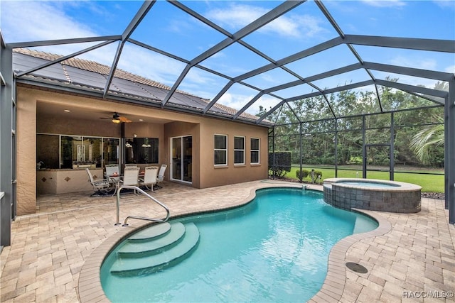 view of pool with glass enclosure, an in ground hot tub, ceiling fan, and a patio