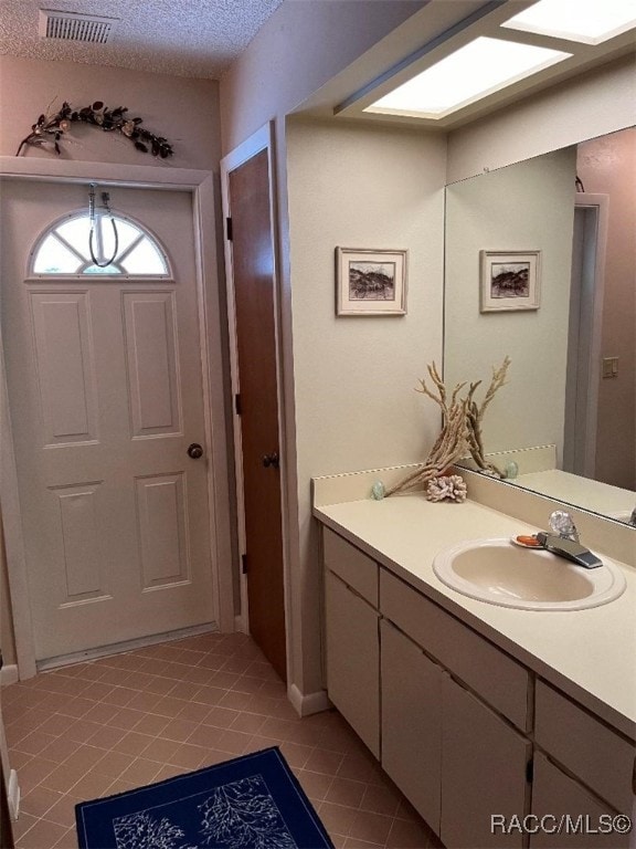 bathroom featuring tile patterned flooring, a textured ceiling, and vanity