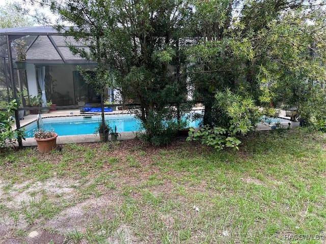 view of swimming pool featuring glass enclosure