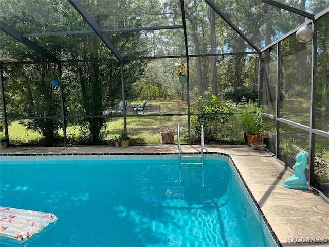 view of swimming pool featuring glass enclosure