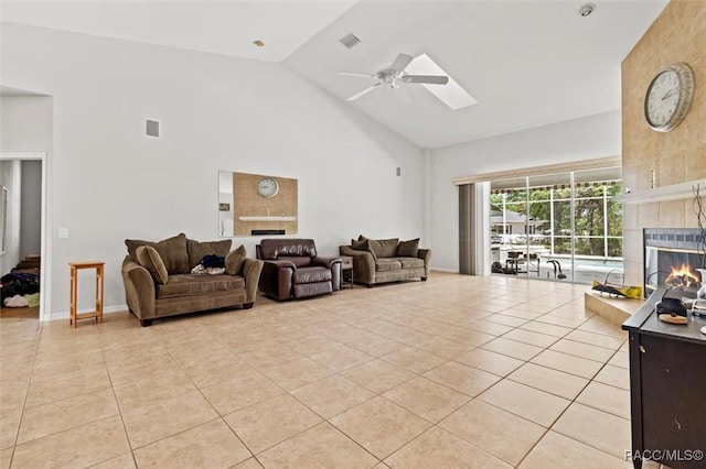 3563 W Blossom Dr, Beverly Hills, FL 34465 - living area with a tile fireplace, high vaulted ceiling, a ceiling fan, light tile patterned floors, and a skylight