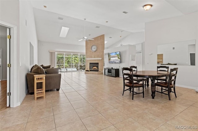 3563 W Blossom Dr, Beverly Hills, FL 34465 - dining room with ceiling fan, a tiled fireplace, high vaulted ceiling, light tile patterned floors, and baseboards