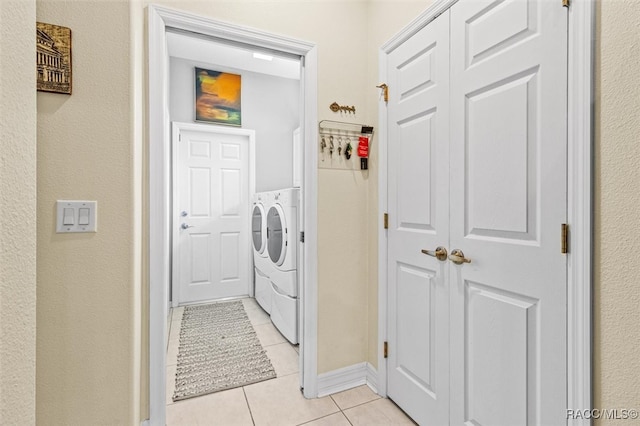 laundry area with light tile patterned floors and washing machine and clothes dryer