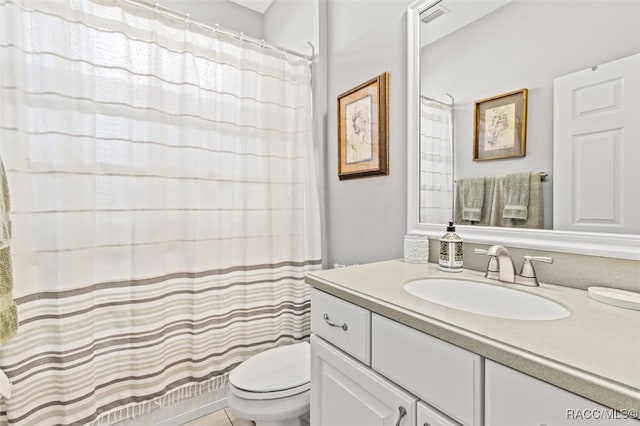 bathroom with curtained shower, vanity, and toilet