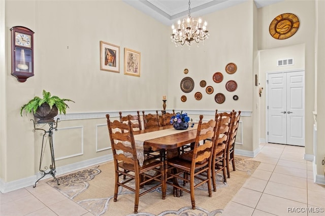 dining room with a chandelier, light tile patterned floors, and ornamental molding