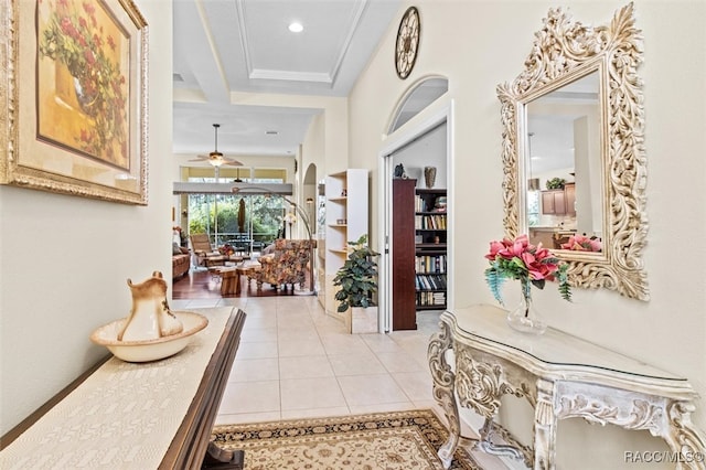 hallway featuring beam ceiling, light tile patterned flooring, and ornamental molding