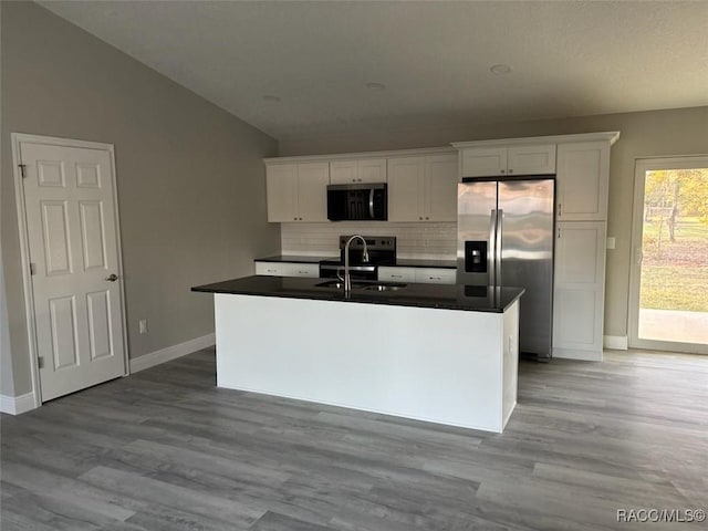 kitchen with appliances with stainless steel finishes, white cabinets, and an island with sink