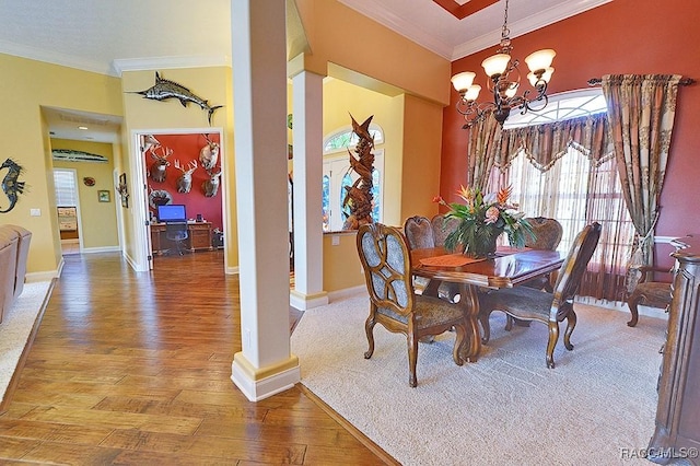 dining room featuring ornate columns, crown molding, wood-type flooring, and an inviting chandelier