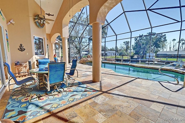 view of swimming pool featuring ceiling fan, a patio, and glass enclosure