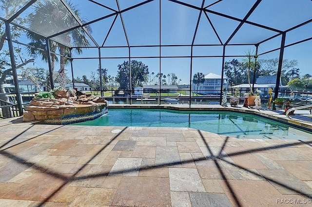 view of pool featuring pool water feature, a patio area, and glass enclosure