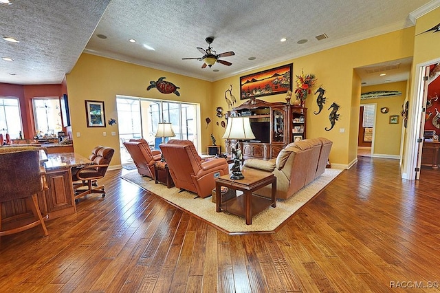 living room featuring hardwood / wood-style floors, crown molding, a textured ceiling, and ceiling fan