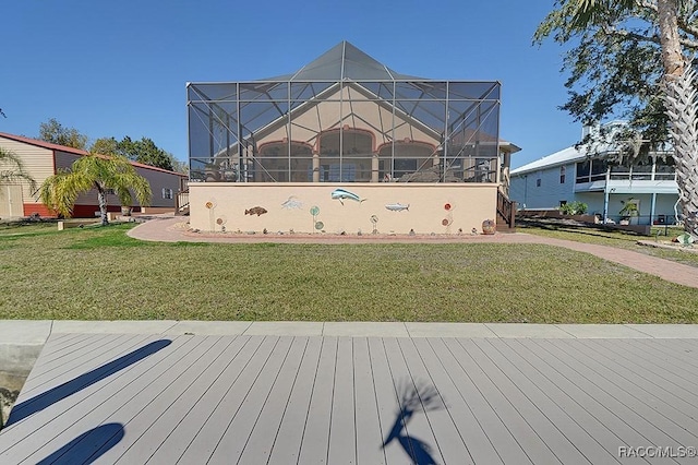 exterior space featuring glass enclosure and a lawn