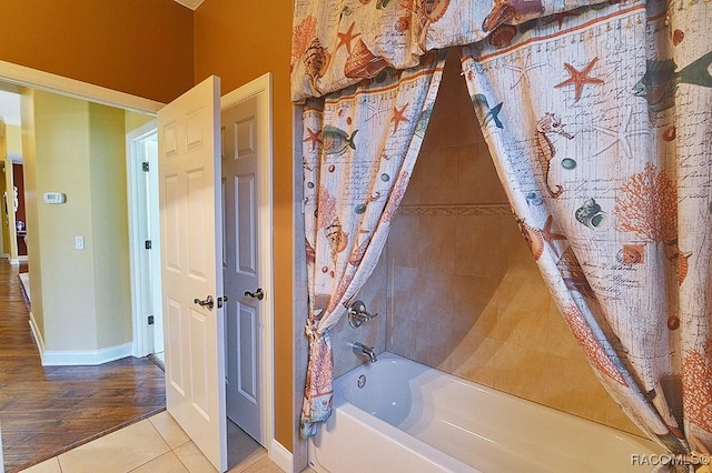 bathroom with shower / bath combination with curtain and tile patterned floors