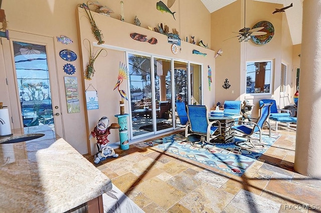 dining area featuring ceiling fan and high vaulted ceiling