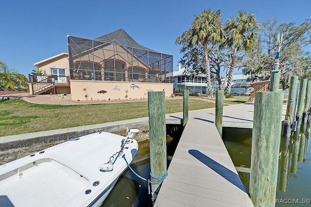 view of dock with a water view, glass enclosure, and a lawn