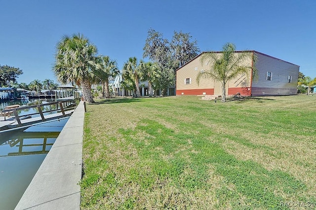 view of yard featuring a water view and a boat dock