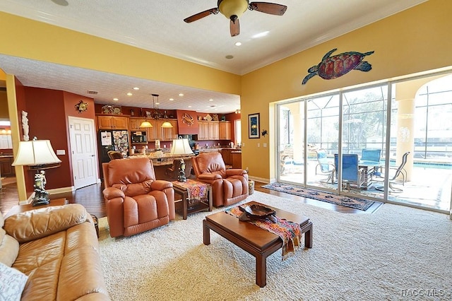 living room featuring crown molding, ceiling fan, and light colored carpet