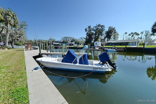 view of dock with a water view and a lawn