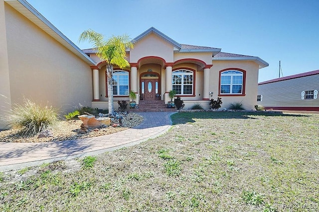 mediterranean / spanish-style house featuring a front lawn