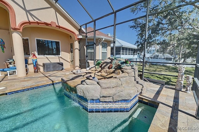 view of pool featuring a patio, pool water feature, and glass enclosure