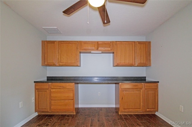 kitchen featuring ceiling fan, dark hardwood / wood-style flooring, and built in desk