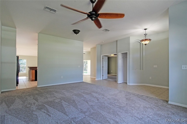 spare room with light carpet, plenty of natural light, and ceiling fan